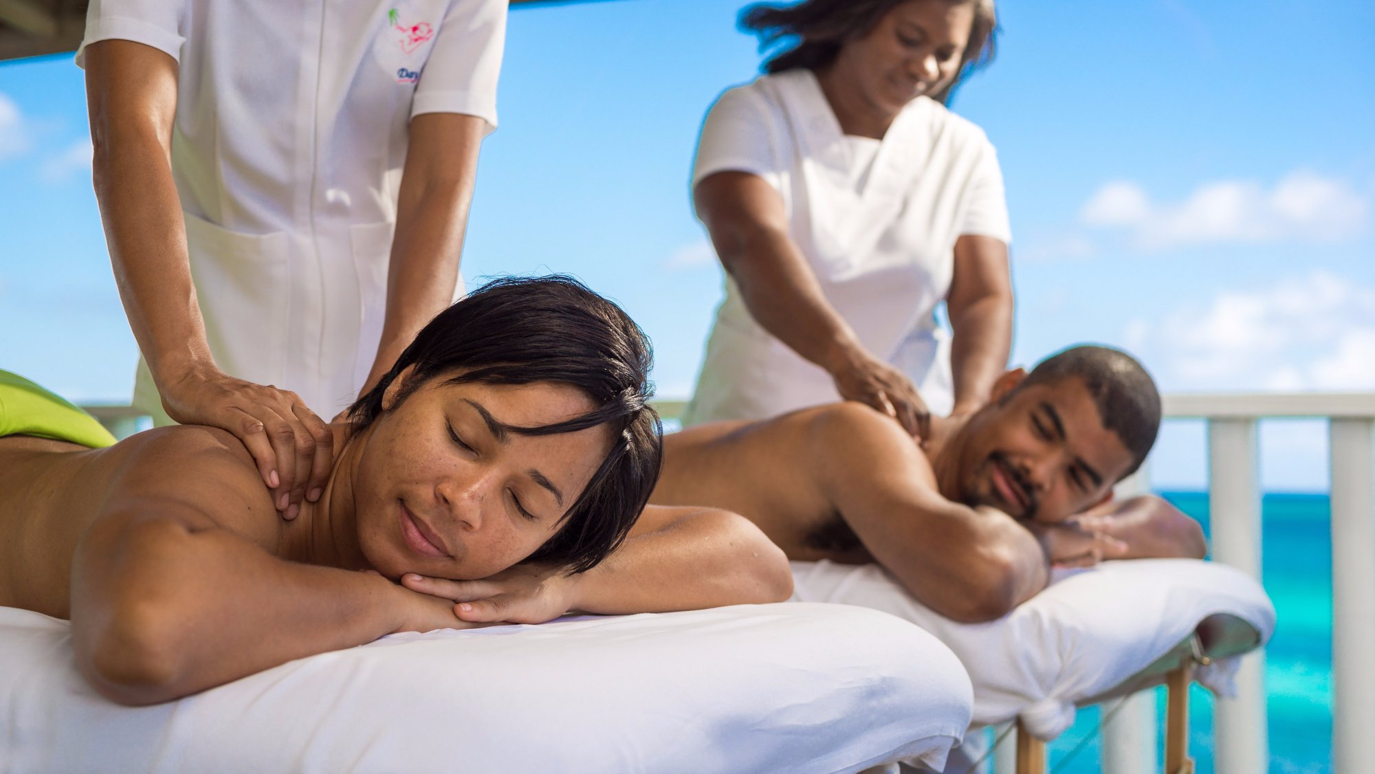 Couples massage in a beach gazebo.