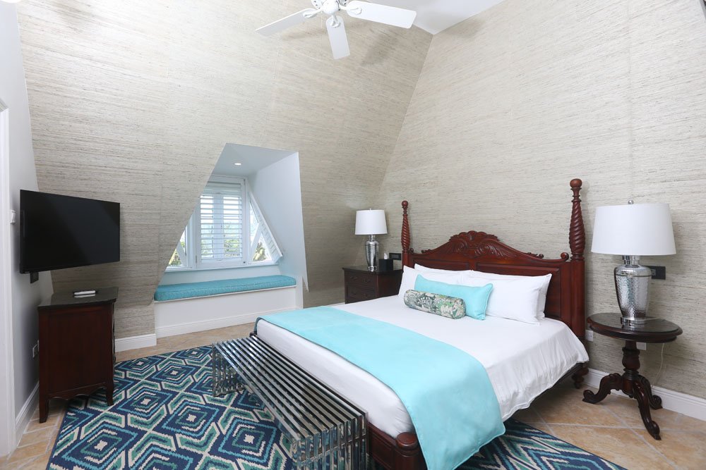 Newly updated master bedroom in suites featuring super size king size bed with plantation shutters, new lighting and foot stool with bedside USB and electrical ports for both US and European guests