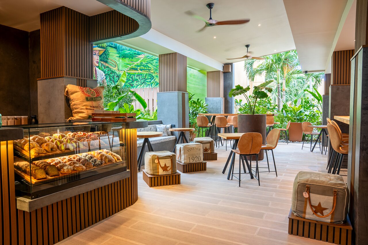 Discover Barista, a modern yet cozy open-air cafe designed for your ultimate comfort. We invite you to savor our bakery-fresh artisan creations, including delicate madeleines, decadent eclairs, flaky croissants, and tempting muffins. This sophisticated and inviting space is the perfect backdrop for enjoying high-quality specialty coffee and tea, creating a truly luxurious moment of escape. Located at the Tamarijn Aruba All Inclusive.