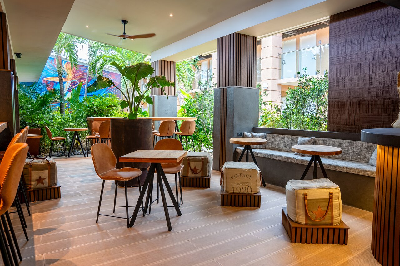 Discover Barista, a modern yet cozy open-air cafe designed for your ultimate comfort. We invite you to savor our bakery-fresh artisan creations, including delicate madeleines, decadent eclairs, flaky croissants, and tempting muffins. This sophisticated and inviting space is the perfect backdrop for enjoying high-quality specialty coffee and tea, creating a truly luxurious moment of escape. Located at the Tamarijn Aruba All Inclusive.