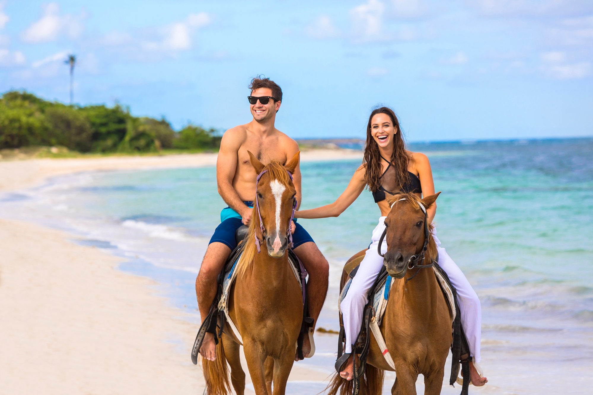 Couple on private horseback riding tour on Serenity's beach